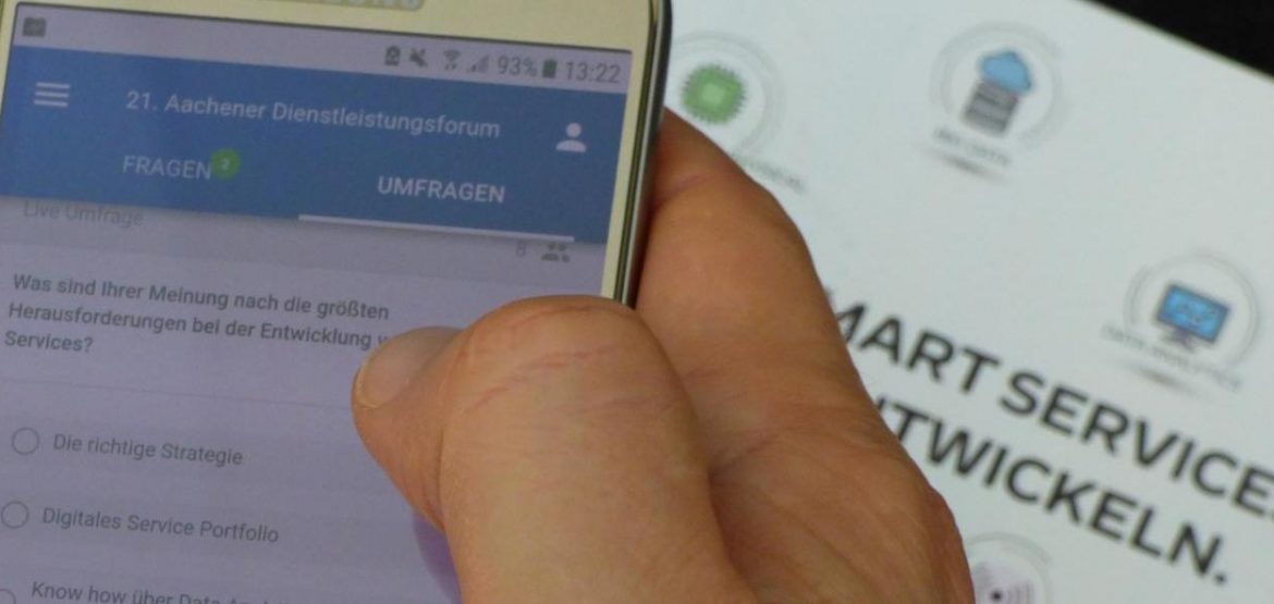 Ein Gast des 21. Aachener Dienstleistungsforum bearbeitet eine Umfrage an seinem Smartphone zum Thema "Smart Services entwickeln"